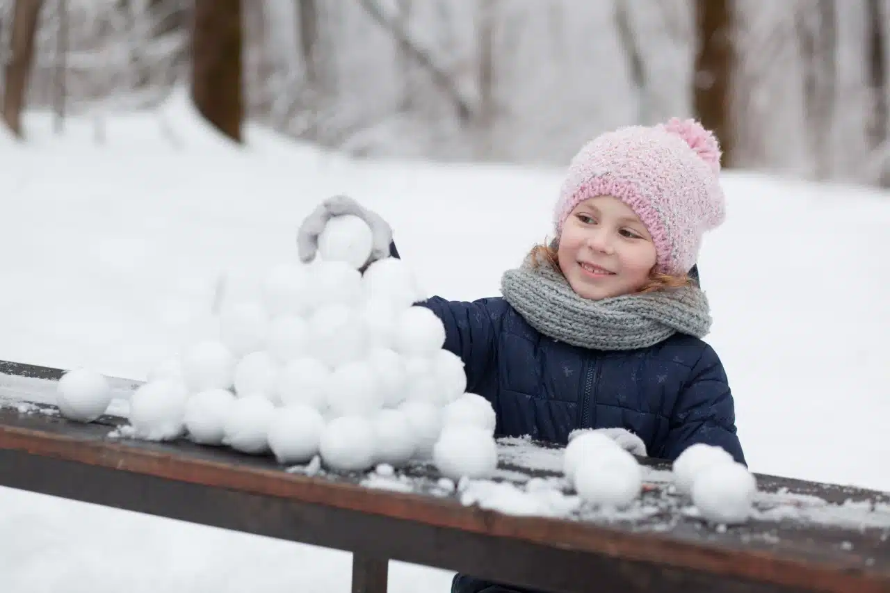 dziewczynka bawiąca się kulkami śniegu